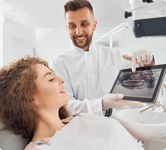 Dentist showing digital X-ray to patient